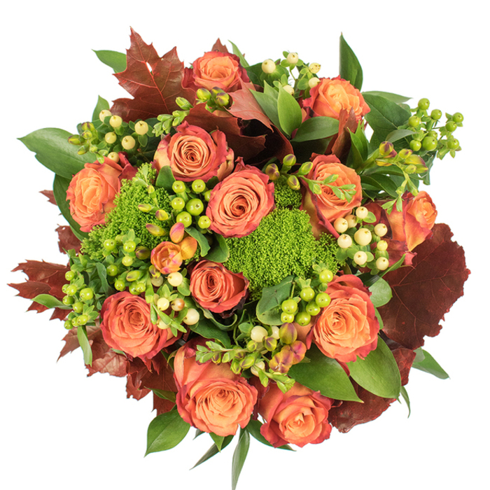 A top-down view reveals a luxurious, circular arrangement that captures the warmth of early autumn: abundant roses in warm peach and vibrant orange form the focal cluster, each blossom showing a delicate gradation of colour from coral cores to russet-tinged outer petals. Between the roses, dense green trick dianthus sits like soft, velvety moss, its rounded texture giving depth and personality to the bouquet, while mixed clusters of hypericum berries - some vivid lime, others a soft cream - scatter bright, glossy notes across the canvas. Broad, glossy green foliage builds a verdant foundation, and interleaved lobed leaves in deep burgundy and burnt orange create a quietly dramatic, seasonal contrast reminiscent of the trees lining London Wall and the planted courtyards around the Barbican Centre. The arrangement is crafted to feel both opulent and approachable: densely packed yet airy at the edges, with shadow and light playing across petals and leaves to emphasise form and softness. One can almost sense the gentle scent of roses balanced by a green, almost herbaceous undertone from the dianthus and the clean, faintly waxy aroma of the berries. Designed to serve as a focal piece for autumn celebrations, Thanksgiving tables, or as a thoughtful seasonal gift for friends living near the Museum of London or Lauderdale Tower, this bouquet offers a tactile richness - velvet petals, smooth berries, and feathery green mounds - that comforts and delights. The careful placement of contrasting textures and tones shows the hand of an experienced florist attentive to colour harmony and the character of Barbican living spaces.